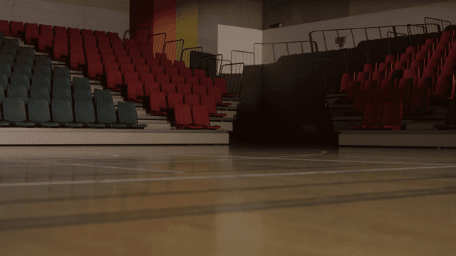 Empty indoor basketball court with seats
