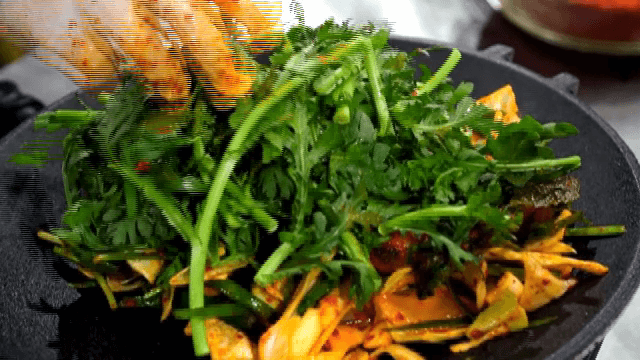 양념된 채소에 쑥갓을 올리는 모습