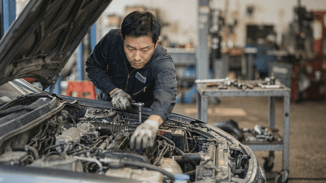 Mechanic working on a car engine in a garage