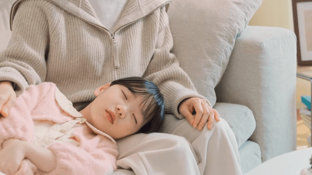 Woman gently patting their sleeping child