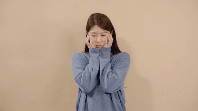 Woman expressing disappointment with her chin resting on her hand and a sad expression