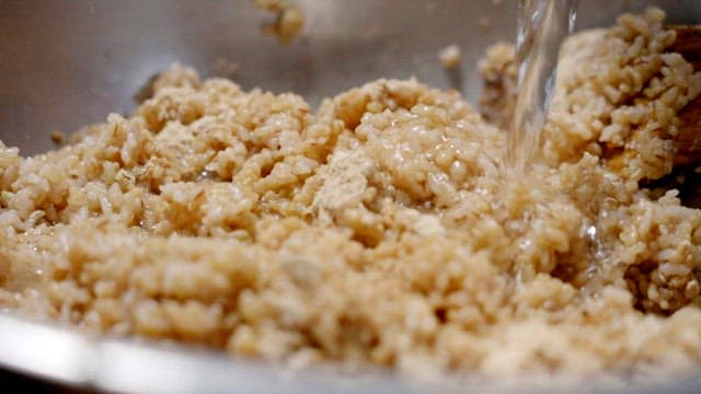 Pouring water into brown rice to make leaven