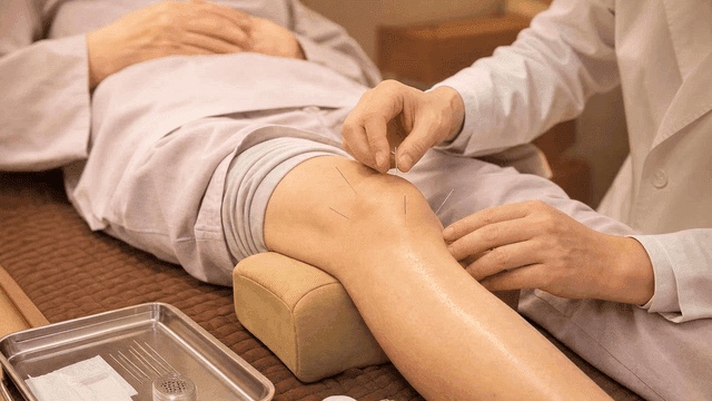 Korean medicine doctor administering acupuncture to patient's knee