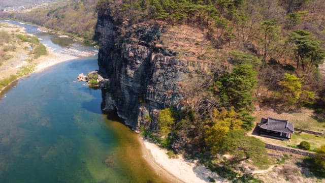 Scenic river flowing beside a cliff