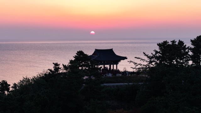 Sunset at a scenic pavilion by the sea with trees