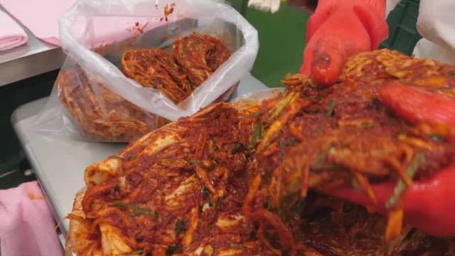 Person preparing and packaging traditional kimchi