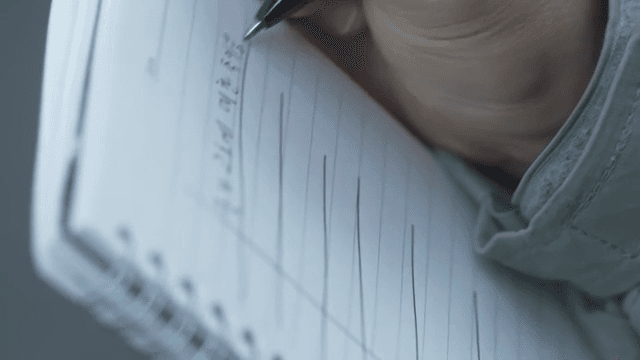 노트에 필기하는 사람