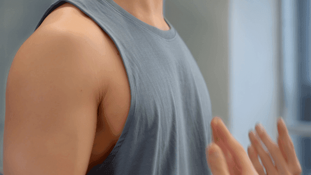 Man stretching arms indoors