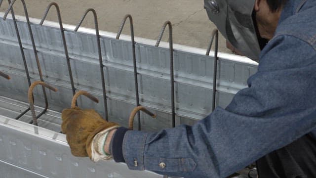 Worker welding metal beams in a factory