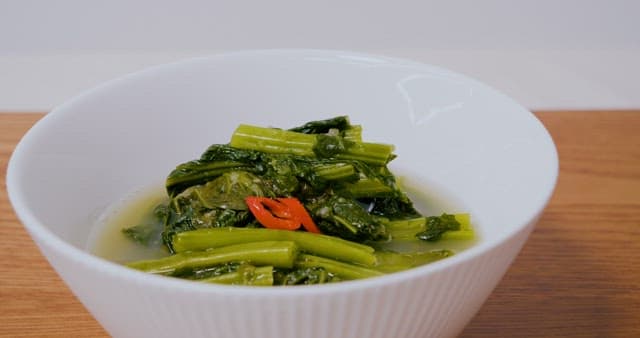 하얀 그릇에 담긴 열무김치를 집어드는 젓가락