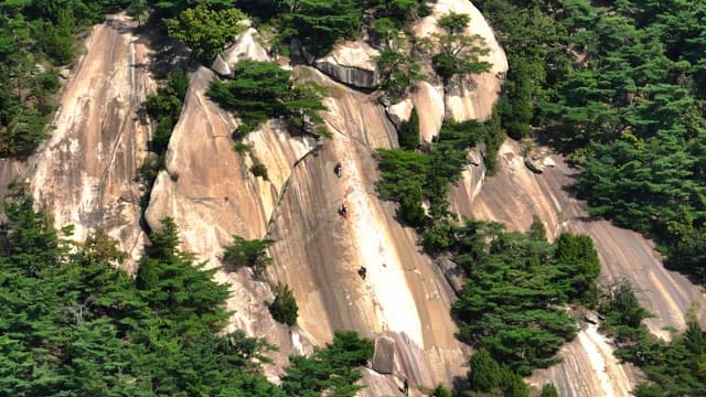 Climbers ascending a steep rocky mountain