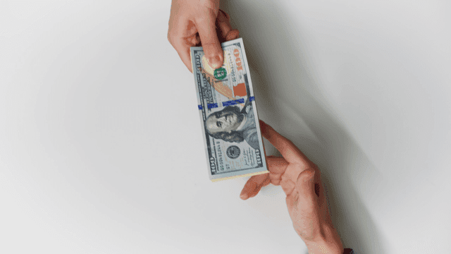 Hands exchanging Korean and US currency