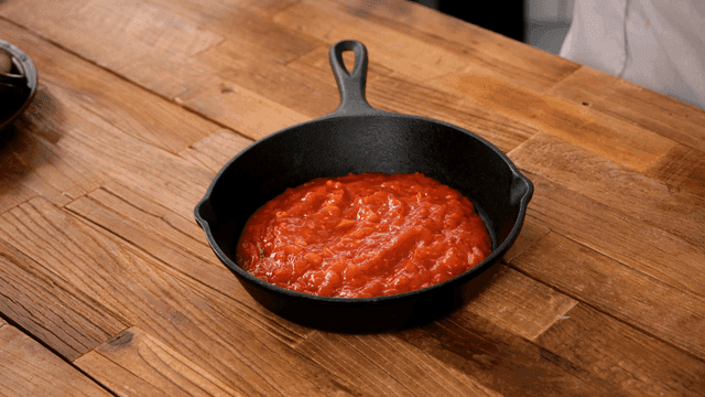 Ratatouille, layering eggplant and tomatoes on top of tomato sauce in pan