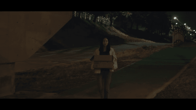 밤에 상자를 들고 걷는 여성