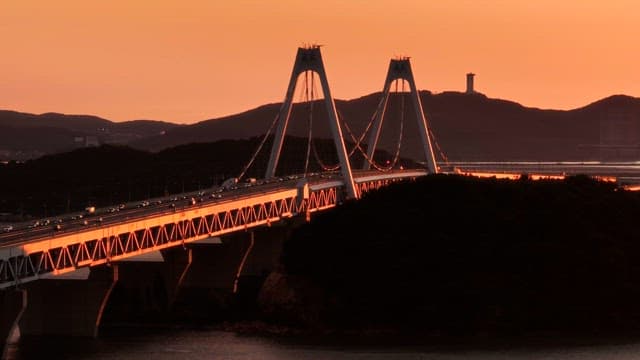 Bridge at sunset with mountains in the background