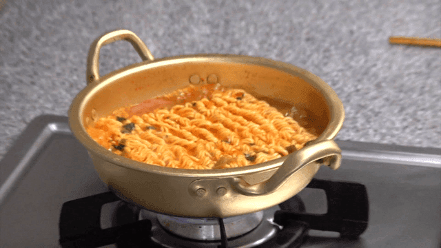 Ramen boiling in an aluminum pot on a home gas stove
