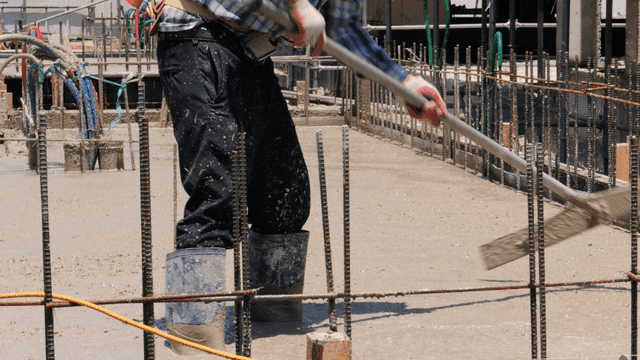 콘크리트를 고르게 하는 건설 노동자