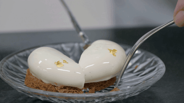 A dessert being sliced with a fork and knife