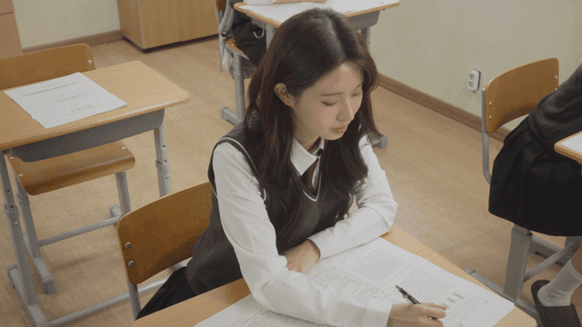 교실에서 웃으며 시험을 보는 여학생