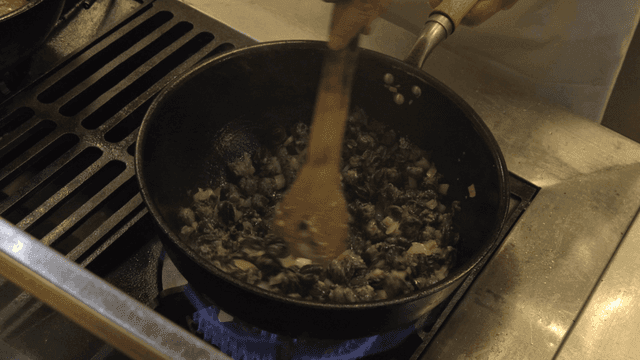 Cooking snails with onions in a pan