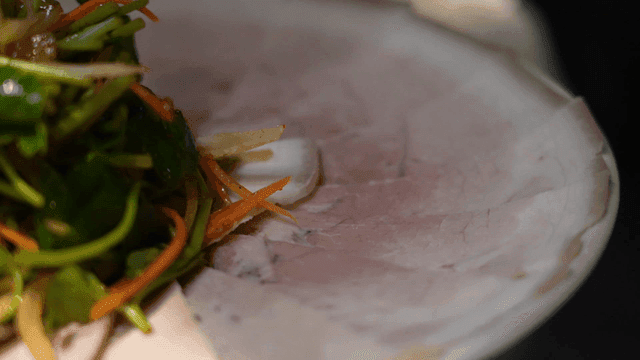 Fresh vegetable salad on top of thinly sliced ​​cold meat