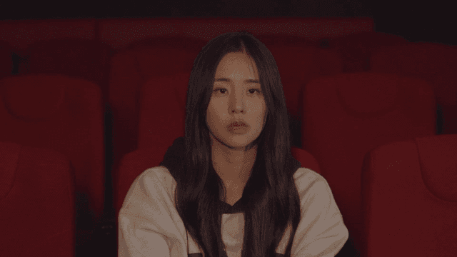 극장 좌석에 앉아 감상에 젖은 여성