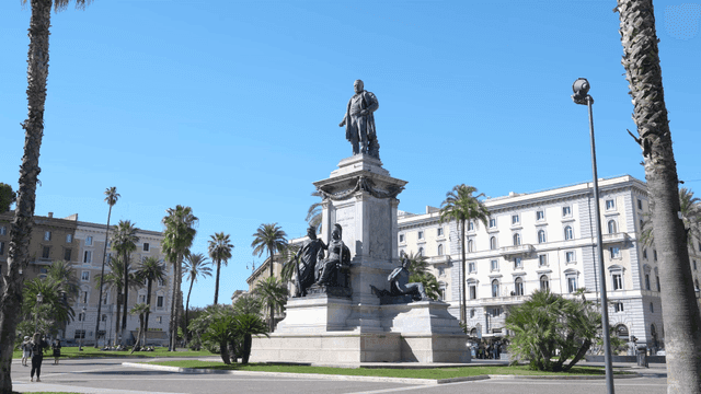 Statue in square with palm trees