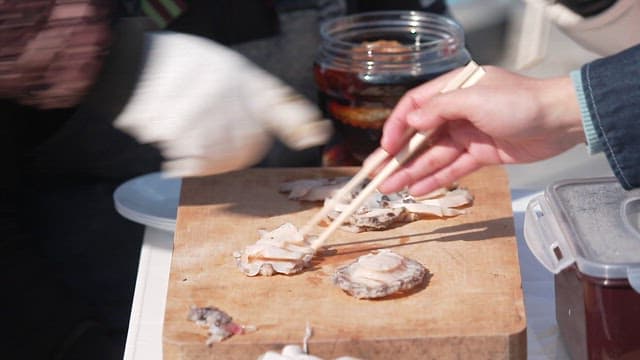 People eating freshly caught and prepared abalone raw abalone