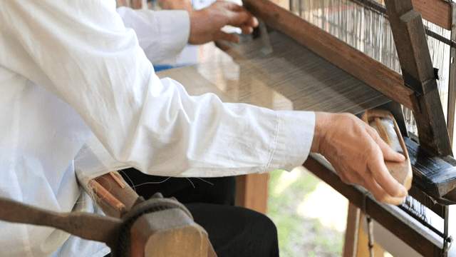 전통 베틀로 천을 짜는 사람