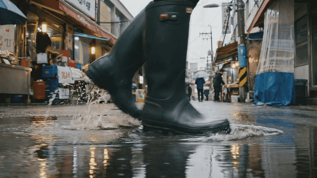 Rain boots walking through puddle in busy street market