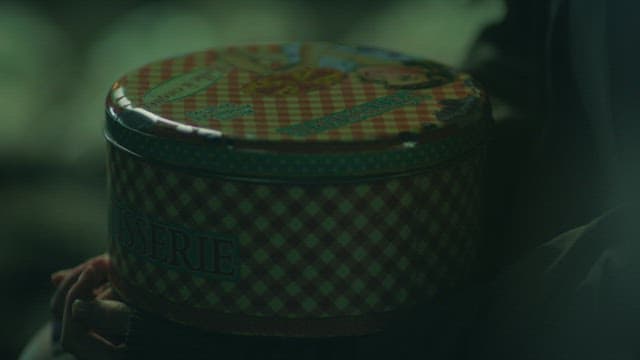 어두운 밤, 틴케이스를 들고 있는 손