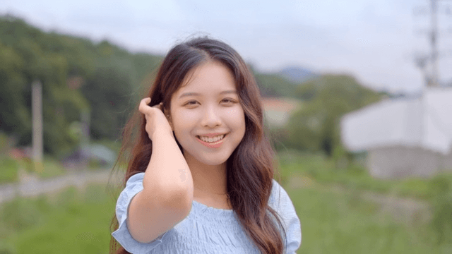 초원에서 미소 짓는 젊은 여성