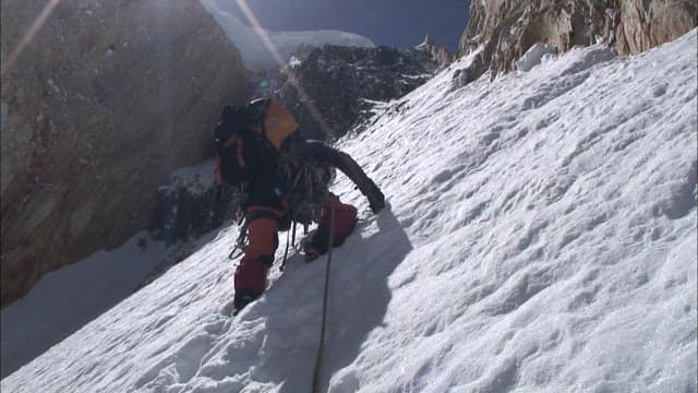 Climber Ascending a Snowy Mountain Slope