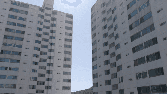 Tall apartment buildings under a bright sun