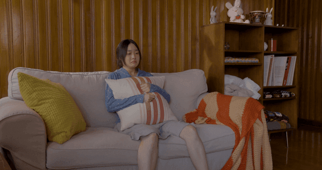 소파에 앉아 눈물 흘리며 우는 여성