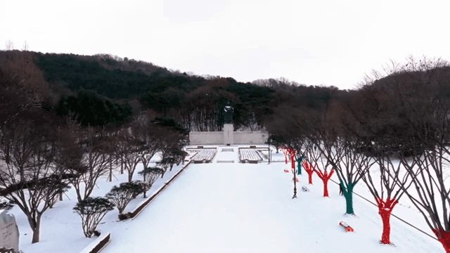 동상과 나무가 있는 눈 덮인 공원