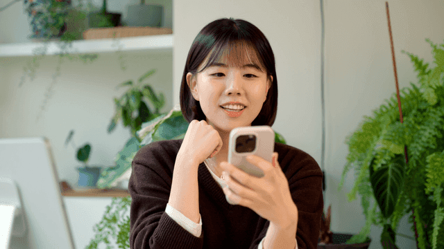 Young woman smiling while looking at her smartphone