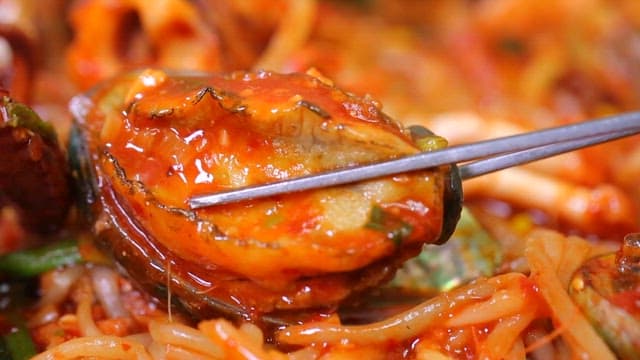 매운 해물찜의 전복을 집어드는 젓가락