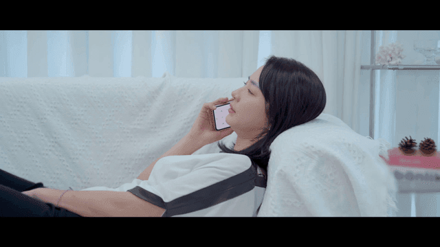 Woman lying on sofa talking on her cell phone