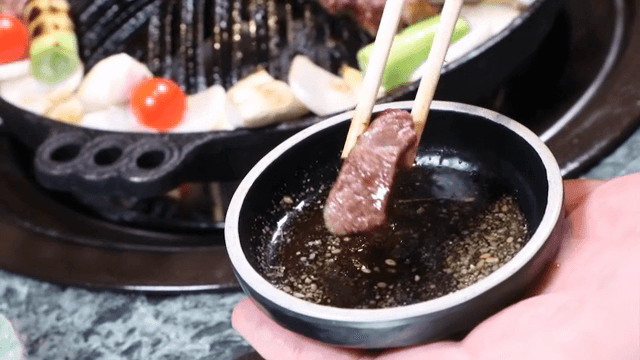 구운 양고기를 소스에 찍는 장면