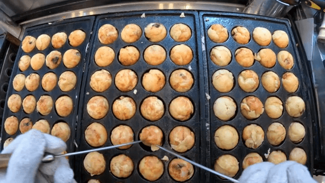 Cooking takoyaki on a hot griddle