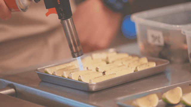 주방에서 라임 조각을 토치로 굽는 모습