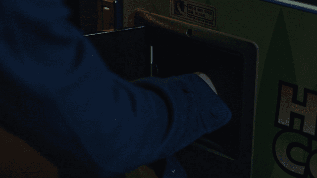 Person taking coffee from vending machine