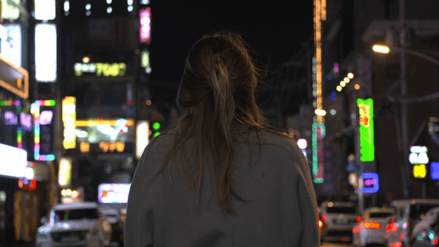 Back view of woman on lively city street