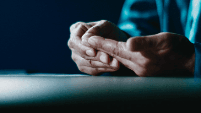 Elderly hands resting on a table