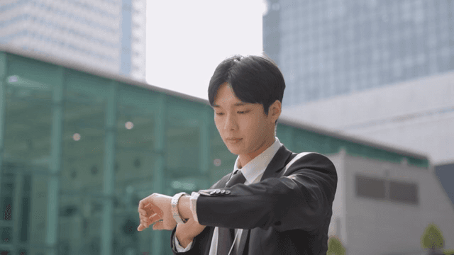 Office worker checking his watch in front of a building