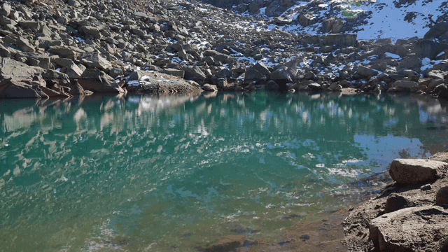 Quiet lake beneath rock with clear water