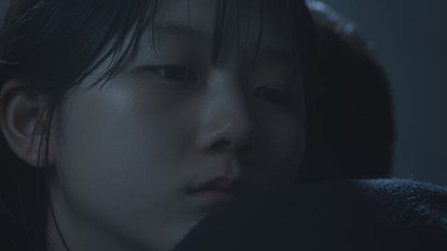 어두운 곳에서 다른 사람의 어깨에 기대 자는 소녀