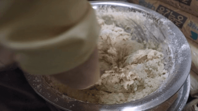 Mixing dough in a large metal bowl