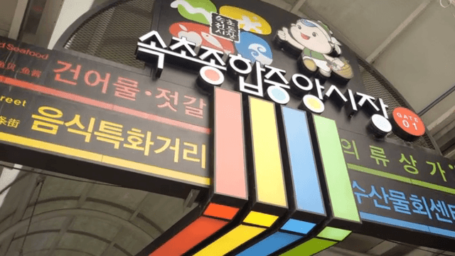 다채로운 간판이 있는 번화한 시장 입구